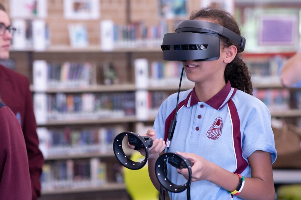 Student using a VR headset and controllers in a classroom – immersive technology in online learning